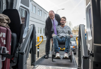 man on a wheelchair entering a car